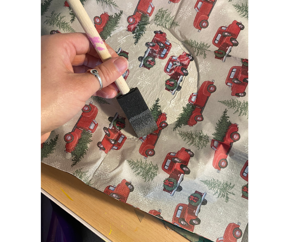 brush applying mod podge to paper napkin on plate